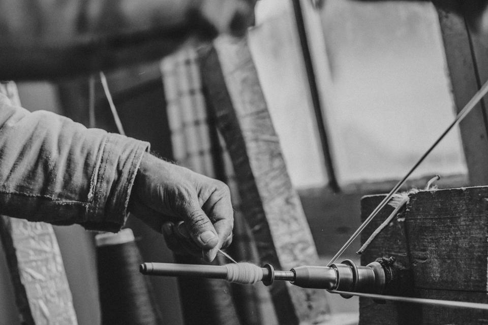 Ein Handwerker beim Handspinnen von Baumwollgarn im AZOR-Atelier