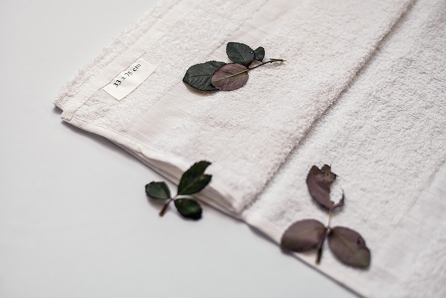 Weißes Badetuch mit Rosenblättern